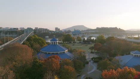Slow-aerial-footage-moving-forward-over-the-carousel-in-Coolidge-Park-over-the-colorful-fall-trees-in-Chattanooga,-TN