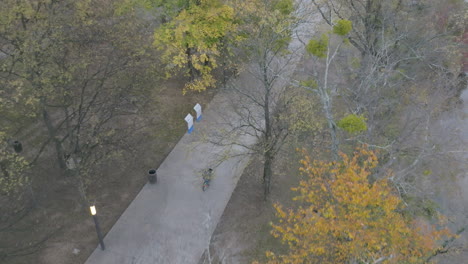 Aerial-footage-following-a-person-riding-their-bike-on-the-sidewalk-next-to-the-Tennessee-River-in-Coolidge-Park