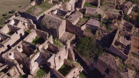 Craco-ruins-on-hill-top-in-Italy-during-sunny-day,-aerial