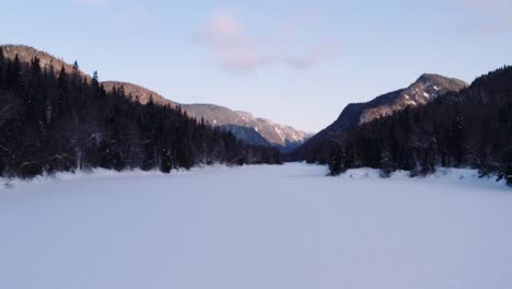 Luftflug-über-Den-Schneebedeckten-Fluss,-Der-Vom-Fjord-Durch-Den-Borealen-Wald-Im-Parc-National-De-La-Jacques-Cartier,-Quebec,-Kanada-Fließt