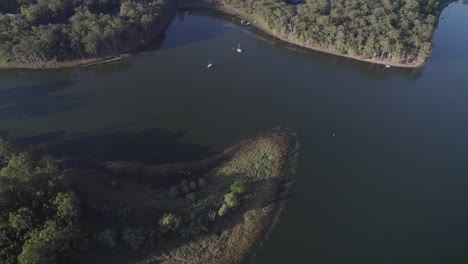 Boote-Auf-Dem-Tinaroo-see,-Umgeben-Von-Grüner-Naturlandschaft-In-Yungaburra,-Queensland,-Australien