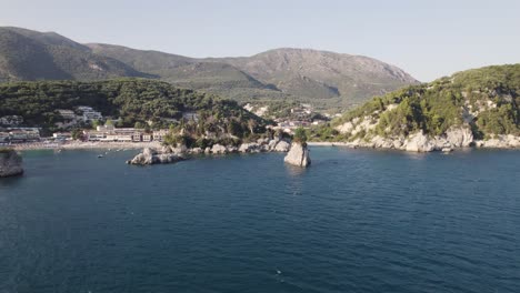 Luftaufnahme-Von-Kleinen-Felseninseln,-Traditioneller-Architektur-Und-Küste-Des-Fischerdorfes-Parga-In-Griechenland