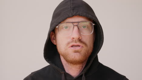 Red-haired-man-in-a-dirty-hoodie-making-an-awkward-rap-on-a-white-backdrop