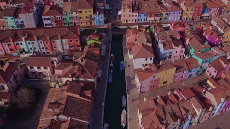 Water-canal-with-boats-running-through-picturesque-colorful-town-of-Burano