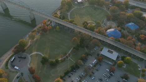 Aerial-flyover-of-Coolidge-Park-on-the-north-shore-of-Chattanooga,-TN-during-the-sunset