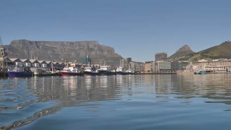 Boats-in-Cape-Town-harbour-viewed-from-water,-Table-Mountain-in-background