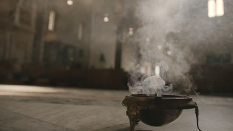 Footage-of-a-bowl-of-incense-on-the-floor-of-a-church-smoking-in-Bari,-Italy