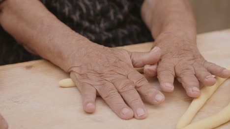 Slow-motion-footage-of-old-hands-rolling-pasta-dough-in-Italy