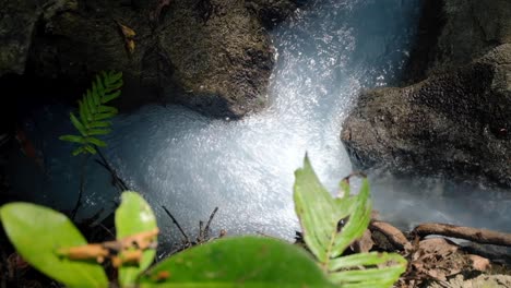 White-sulphur-water-stream-flowing-and-bubbling-through-rocks,-top-down-view,-on-remote-island-of-Timor-Leste,-Southeast-Asia