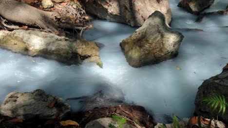 Sulphur-stream-with-white-milky-water-flowing-through-rocks-on-the-remote-tropical-island-of-Timor-Leste,-Southeast-Asia