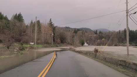 Steigende-Wasserstände-Durchbrachen-Das-Flussufer-Und-überschwemmten-Eine-Landstraße-Und-Die-Umgebung