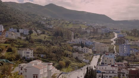 Weiter-Blick-Auf-Blaue-Gebäude-Rund-Um-Eine-Straße,-Die-Ein-Tal-Durchquert,-Das-Zur-Stadt-Chefchaouen-In-Marokko-Führt