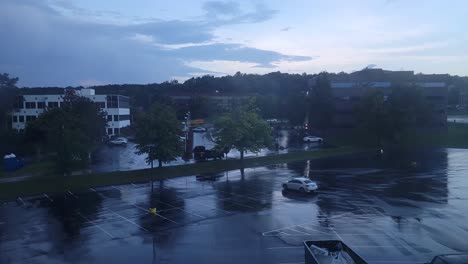 High-angle-shot-over-a-parking-lot-outside-the-office-building-on-a-rainy-day-in-timelapse
