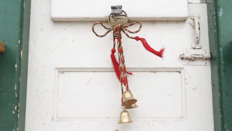 Holiday-bells-hanging-on-a-rustic-white-door