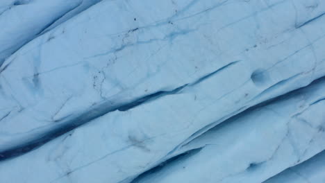 Overhead-rising-shot-of-streaks-and-cracks-in-glacier