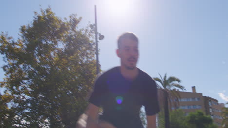 Dynamische-Mittlere-Aufnahme-Eines-Jungen-Kaukasiers,-Der-Auf-Einem-Straßenbasketballplatz-In-Barcelona,-Spanien,-Dribbelt,-Schießt-Und-Korb-Spielt