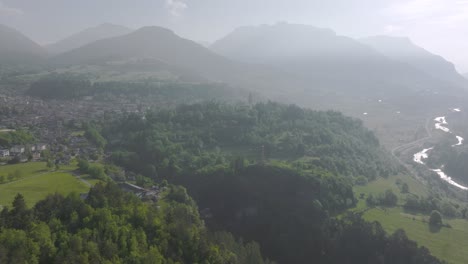 Vista-Aérea-Del-Valle-De-Fiemme-Rodeado-De-Naturaleza-Verde-Y-Silueta-De-Montañas-Durante-El-Día-De-Verano