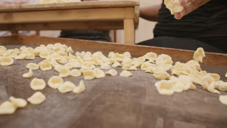 Close-up-slow-motion-footage-of-a-lady-throwing-freshly-made-conchiglie-shells-onto-a-net