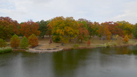 Pull-back-over-a-pond-and-away-from-trees-in-the-park-in-Kirkwood-in-Autumn-on-a-pretty-day