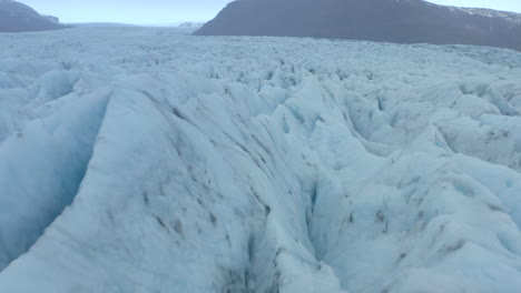 Niedrige-Filmische-Luftaufnahme-über-Risse-Und-Grate-In-Einem-Großen-Gletscher