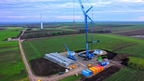 Luftaufnahme-Einer-Baustelle-Mit-Windkraftanlagenteilen-Und-Maschinen-Auf-Dem-Boden