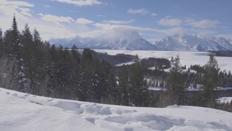 Handheld-panning-shot-of-the-Teton-Range-with-snow-and-the-Snake-River-in-the-foreground