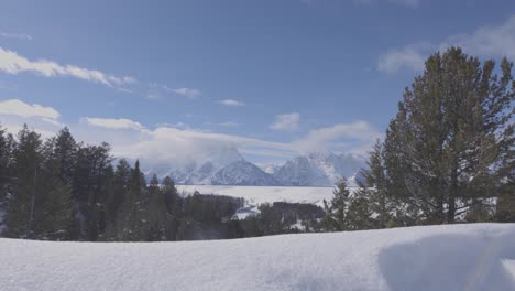 Low-angle-handheld-shot-of-the-Teton-range-in-western-Wyoming-with-snow-in-the-foreground