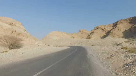 Shot-of-mountain-range-and-desert-road-from-car