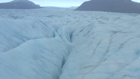 Low-close-up-shot-of-cracks-and-ridges-in-large-glacier
