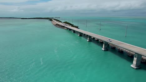 Over-seas-highway-Florida-keys-bridge,-aerial-panning-view-with-blue-water