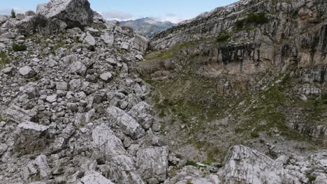 Aerial-tilt-up-of-stony-boulders-and-slackline-jumper-on-mountaintop-of-Dolomite---Cinematic-drone-shot