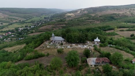 Bahnaufnahme-Der-Markanten-Kirche-Auf-Dem-Grünen-Hügel,-Berge-Im-Hintergrund,-Rumänien