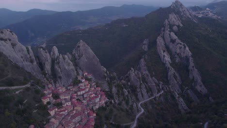 Early-morning-above-picturesque-mountain-village-in-Italy-with-rock-formations,-aerial