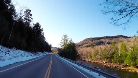 Road-trip-from-New-Hampshire-to-Vermont-along-Highway-89-snowy-roadside,-POV-shot