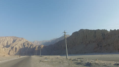 Shot-of-mountain-range-and-desert-road-from-car
