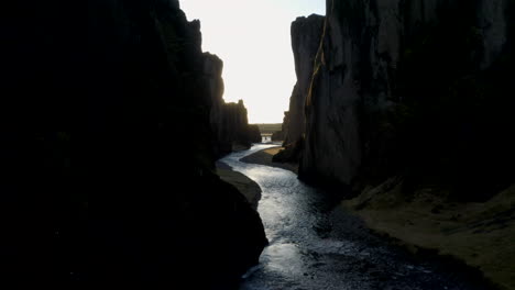 Aerial-shot-through-Fjaðrárgljúfur-canyon-towards-the-sunrise