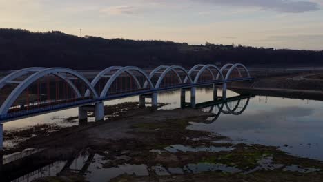 Eisenbahn-Bogenbrücke-überspannt-Den-Skawa-Fluss-Mit-Seichtem-Und-Ruhigem-Wasser-Während-Des-Sonnenuntergangs