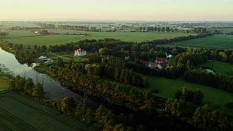 Villa-With-Boat-Surrounded-By-Green-Fields-Along-The-River-In-The-Countryside