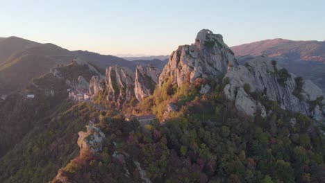 Dolomiti-Lucane-mountain-range-rock-cliffs-during-golden-hour,-aerial