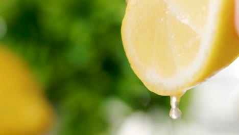 Nahaufnahme-Einer-Halben-Zitrone,-Die-Frischen-Zitronensaft-Freisetzt,-Zeitlupenaufnahme