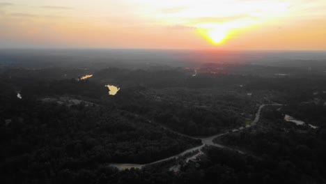 Amazing-cinematic-4K-sunset-residential-drone-footage-after-deforestation-issue-consists-of-homes,-road,-trees,-lake-and-infrastructure-in-the-middle-of-tropical-forest-located-in-Riau,-Indonesia