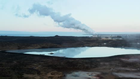 White-milky-silica-run-off-pool-in-Iceland-with-distant-smoke-coming-from-power-plant