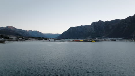 Drone-circles-industrial-harbor,-port,-dock-in-Lofoten,-Norway