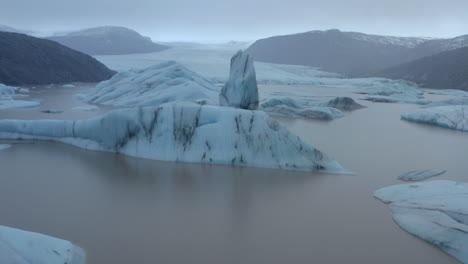 Low-circling-aerial-shot-around-blue-icebergs