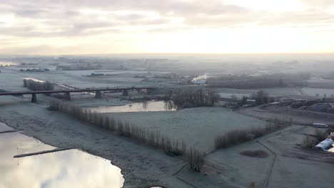 Icy-winter-rural-landscape-by-the-river-over-Dutch-farmlands