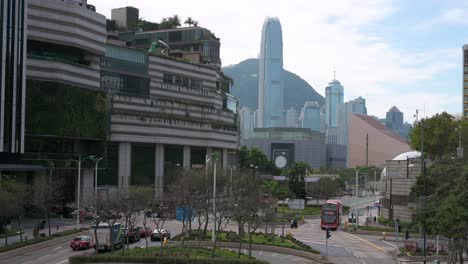 Fahrzeuge-Fahren-Und-Reisen-Entlang-Einer-Straße,-Während-Die-Wolkenkratzer-Und-Das-Finanzviertel-Von-Hong-Kong-Im-Hintergrund-Zu-Sehen-Sind