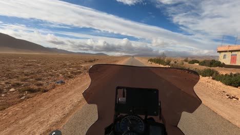 motorcycle-driving-in-a-strong-wind-through-the-middle-of-the-desert-with-objects-moved-by-the-strong-wind