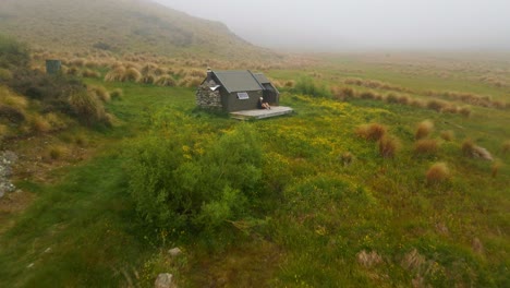 Spurs-Hütte-In-Mackenzie,-Neuseeland,-Mit-Wanderer,-Der-Sich-Nach-Einer-Langen-Wanderung-Auf-Dem-Deck-Entspannt