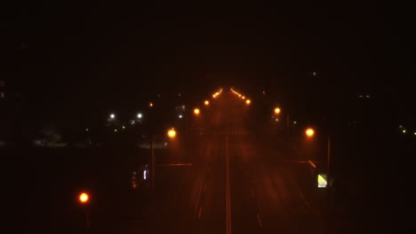 Spooky-road-and-street-lights-at-night-with-an-empty-road