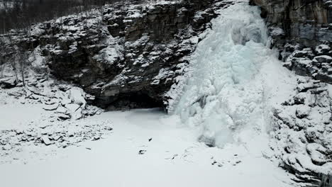 Monochrom-Eines-Gefrorenen-Wasserfalls,-Der-Im-Winter-In-Nordnorwegen-Von-Felsigen-Klippen-Fließt